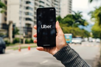 Girl,On,The,Street,Holding,Smartphone,With,Uber,App,On