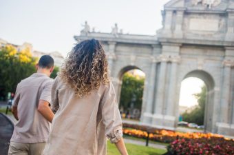 Couple,Walking,Towards,Puerta,De,Alcala,In,Madrid,,Spain